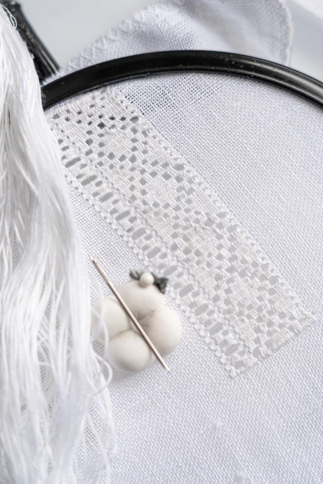 Close-up of stitched floral motif on linen